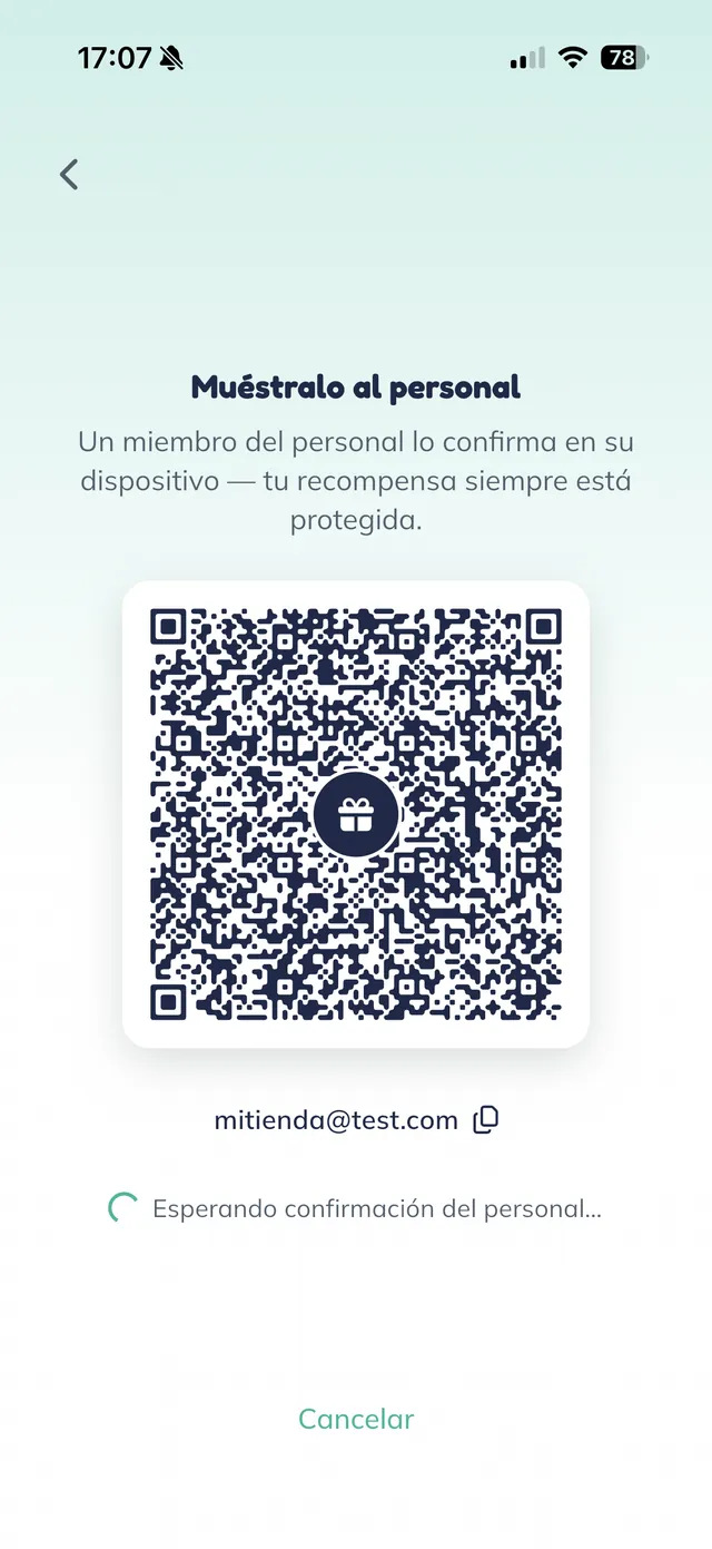 Pantalla "Muéstralo al personal" en el teléfono del cliente, con un código QR grande con un ícono de regalo al centro, el correo del cliente debajo y el aviso "Esperando confirmación del personal".